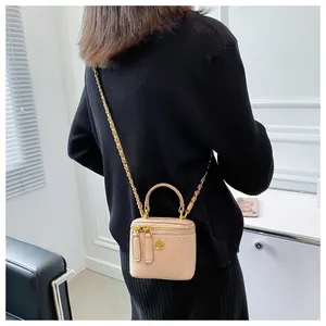 Model view of a mini pink quilted chain bag with gold camellia floral hardware
