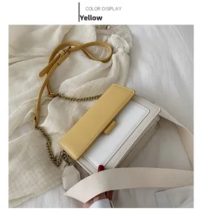 Detail showing contrast yellow and white crossbody bag with stylish chain and fabric straps