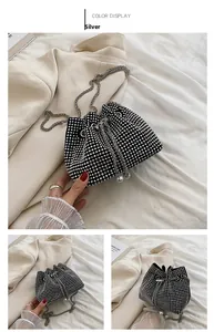 Detail of silver rhinestone bucket bag with chain strap and pearl drawstring accents