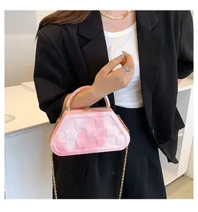 Detail of pink marble textured crossbody bag with gold handle and bear embossing
