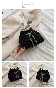 Detail view of a black rhinestone drawstring bucket bag with a silver chain shoulder strap