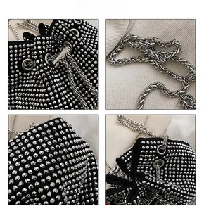 Macro view of sparkly rhinestone bucket bag with silver chain strap and drawstring detail