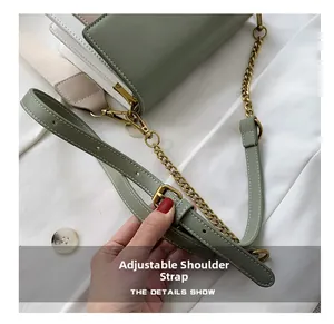 Adjustable green leather shoulder strap and gold chain detail on a trendy crossbody bag