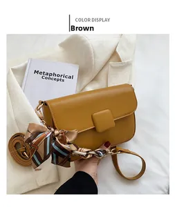 Detail of brown faux leather crossbody bag with geometric silk scarf and gold hardware