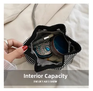Detail view of rhinestone bucket bag interior capacity with cosmetics and silver chains