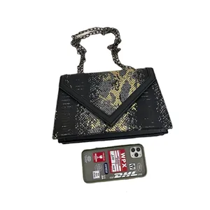 Sac bandoulière tendance à motif serpent avec bandoulière chaîne sur fond blanc