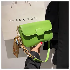 Detail of neon green leather shoulder bag with silk scarf chain and square buckle