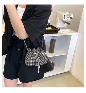 Detail of silver rhinestone mini bucket bag with pearl drawstring and metal chain strap