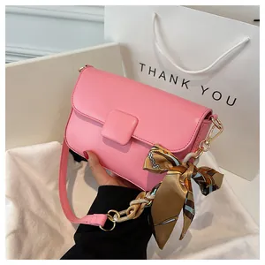 Pink faux leather shoulder bag with silk scarf wrapped chain handle and square buckle