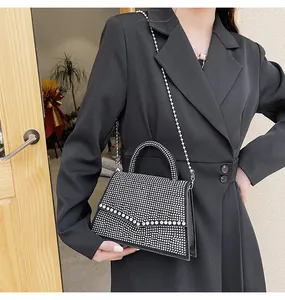 Dettaglio dell'elegante borsa da sera nera con strass scintillanti e catena d'argento