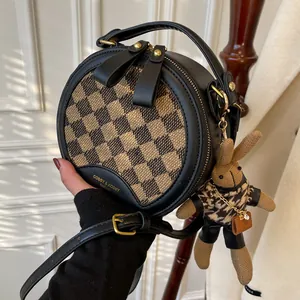 Chique ronde crossbodytas met ruitpatroon, leren bies en pluche konijnenhanger