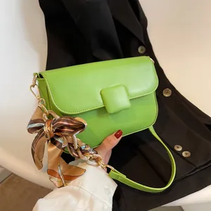 Vibrant green leather shoulder bag with printed silk scarf and acrylic chain handle