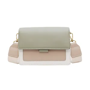 Chic tri-color leather crossbody bag with green flap and wide cream shoulder strap