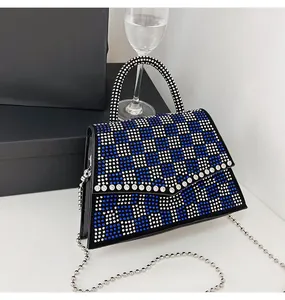 Dettaglio macro della borsa da sera a scacchi in strass blu e bianchi con catena