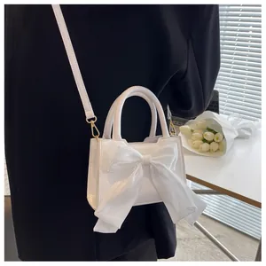 White mini handbag with elegant organza bow detail and gold metal hardware strap