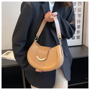 Details einer kamelfarbenen Satteltasche aus mattem Leder mit goldener Halbmondschnalle