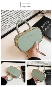 Close-up of light green oval handbag with golden metal trim and woven handle details