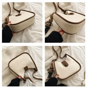Detailoverzicht van de crème-bruine emmer tas met een schattige konijnen hanger