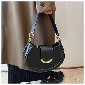 Details der schwarzen Satteltasche mit glatter Halbmondform und goldener Schnalle