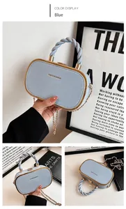 Detail of light blue box bag with lychee grain leather, gold frame, and chain strap