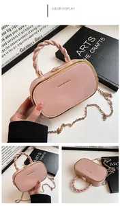 Detail of pink oval box bag with lychee texture leather and gold metal frame hardware