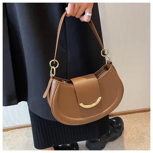 Detail der braunen Satteltasche mit goldener Metallschnalle und elegantem Lederriemen