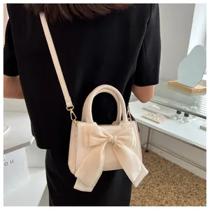 Detail of cream PU leather handbag with oversized silk bow and gold-tone hardware