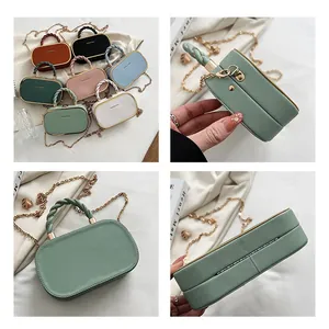 Detail van mini box bag met geweven handvat en dunne metalen ketting schouderband
