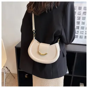 Modell mit schicker beiger Satteltasche und Goldschnalle über einem schwarzen Blazer