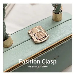 Detailed close-up of mint green lychee grain leather handbag with golden metal buckle