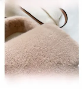 Détail macro de la texture en fausse fourrure et de la poignée en cuir du sac beige