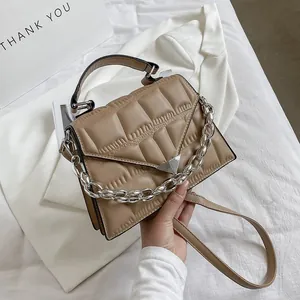 Macro view of khaki quilted PU leather bag with silver chain and metal triangle clasp