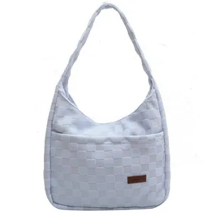 Light blue checkered woven shoulder bag with front pocket and long strap for women