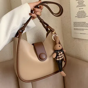 Modieuze beige en bruine emmertas met verstelbare riem en schattige konijnenhanger