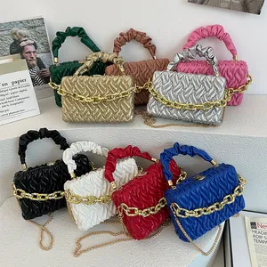 Quilted handbags in various colors featuring gold chains on a stylish tiered display
