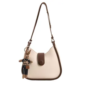 Chique crème Hobo schoudertas met bruine leren bies en schattige konijnen hanger
