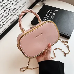 Roze modieuze box-handtas met geweven handvat en gouden ketting op artistieke achtergrond