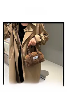 Macro detail of dark brown plush teddy fleece handbag with golden metal hardware
