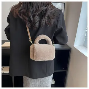Détail d'un sac à main en peluche kaki montrant la fourrure douce et la bandoulière en cuir