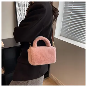 Détail d'un sac à main en fausse fourrure rose avec ferrures dorées sur un blazer