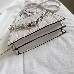Top view of cream white quilted crossbody bag with silver chain detail and layered structure