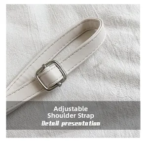 Detail of adjustable white leather shoulder strap with silver square metal buckle and stitching