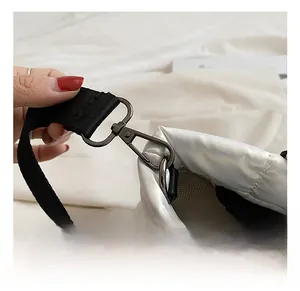Detail of premium black metal hook and quilted silver nylon fabric on tote bag