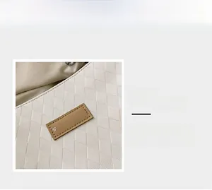 Dettaglio della borsa tote trapuntata crema con texture a rombi e toppa con logo