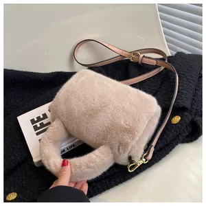 Détail du sac à main beige en fausse fourrure avec bandoulière et boucles dorées