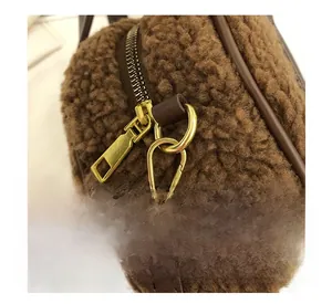 Close-up of golden metal zipper and dark brown plush lamb wool texture on bag