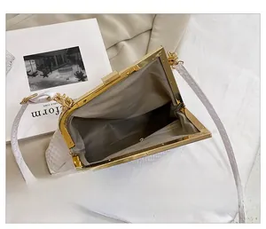 Detailansicht der weißen Abendtasche mit Futter und goldenem Metallverschluss innen