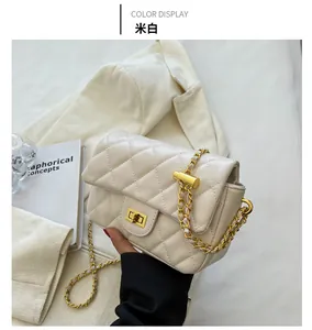 Detail of off-white quilted chain bag with gold hardware and metal adjustment buckle