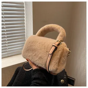 Vue détaillée de la texture en fausse fourrure d'un sac bandoulière beige avec lanière