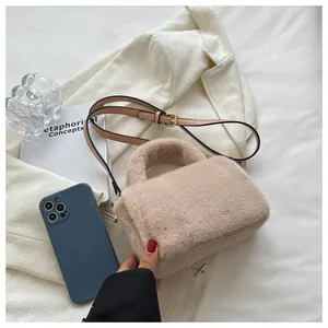 Vue détaillée du sac à main en peluche beige avec bandoulière réglable en cuir marron